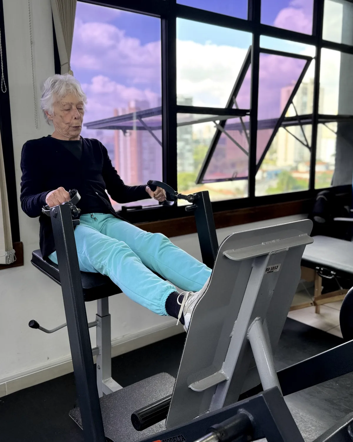 Pessoa realiza exercício de leg press em equipamento adaptável na EPrime